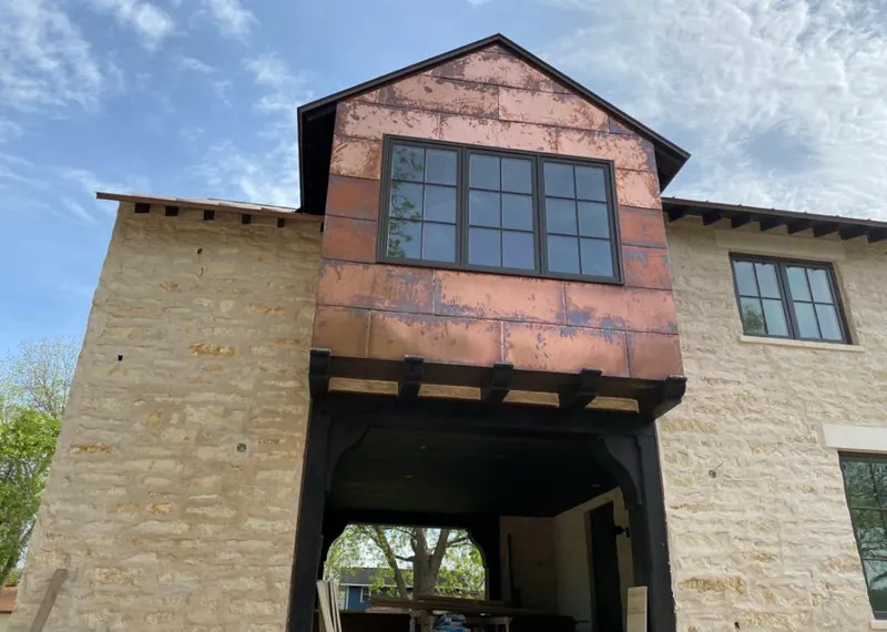 Copper metal panel facade on a stone building for Roof Repair in Horizon West